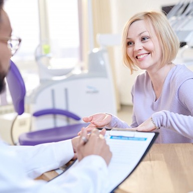 woman discussing the cost of sleep apnea treatment with dentist