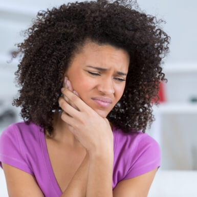 Woman holding face due to ear and neck pain