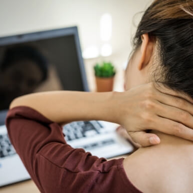 Woman holding neck in pain