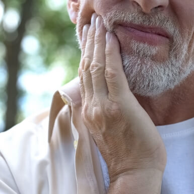 Man holding jaw in pain