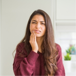 Woman holding cheek due to jaw and face pain