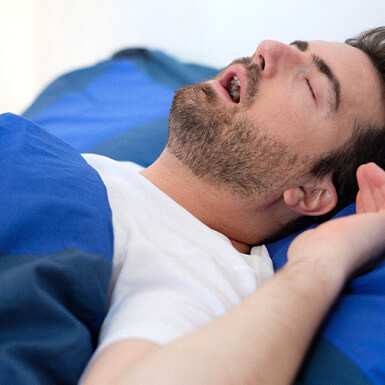 man snoring in bed