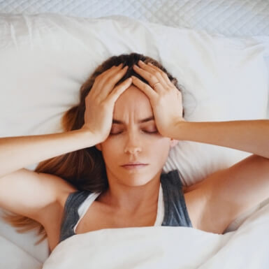 Woman waking with headache caused by T M J disorder