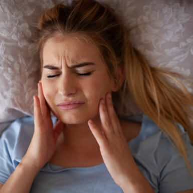 Woman holding jaw in pain