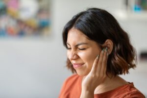 Grimacing woman experiencing tinnitus