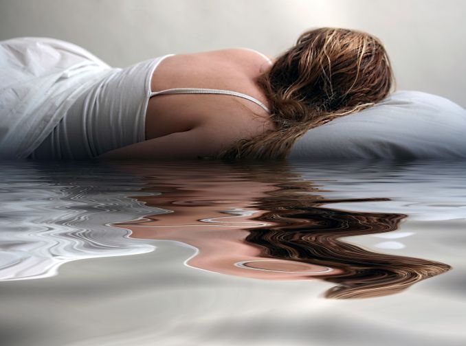 An artistic image of a woman sleeping in a puddle